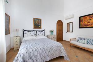 una camera bianca con un letto e un divano di Estate4home - Angolo di Paradiso a Positano