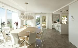 cocina y comedor con mesa de madera y sillas en Villa Pacifica en Santa Cristina de Aro