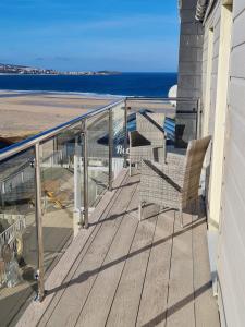 a balcony of a house with a view of the beach at Sandy Bay Apartment, St Ives Bay, Hayle in Hayle