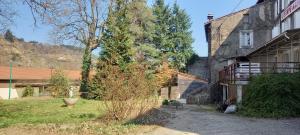 a house with a tree next to a building at Les ressources d'Epione in Lamastre