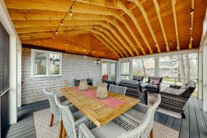 a screened porch with a wooden table and chairs at Sit Back & Relax in Eastham