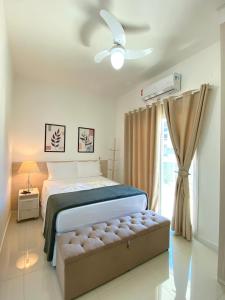 een slaapkamer met een bed en een plafondventilator bij Apto Bella Citta em Cabo Frio in Cabo Frio