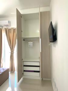 een woonkamer met een deur naar een kamer met een televisie bij Apto Bella Citta em Cabo Frio in Cabo Frio