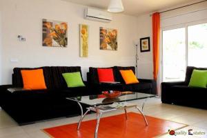 salon z czarną kanapą i kolorowymi poduszkami w obiekcie Villa Rosa w mieście Calonge