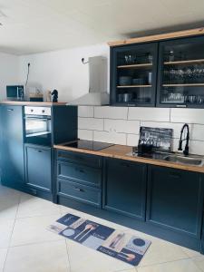 eine Küche mit blauen Schränken und einer Arbeitsplatte in der Unterkunft Ferienwohnung Burkhart in Bundenthal