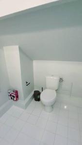 uma casa de banho com um WC branco num piso de azulejo branco em Studio fonctionnel proche gare Pierrefitte Stains "Appart 2" em Pierrefitte-sur-Seine