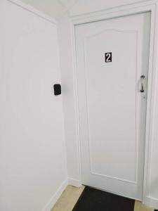 Una puerta blanca con el número. en Studio fonctionnel proche gare Pierrefitte Stains "Appart 2", en Pierrefitte-sur-Seine