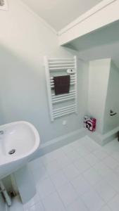 uma casa de banho branca com um lavatório e uma janela em Studio fonctionnel proche gare Pierrefitte Stains "Appart 2" em Pierrefitte-sur-Seine