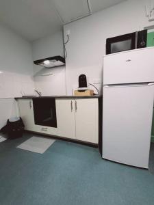 uma cozinha com um frigorífico branco e um micro-ondas em Studio fonctionnel proche gare Pierrefitte Stains "Appart 2" em Pierrefitte-sur-Seine