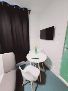 um quarto com uma mesa, uma cadeira e uma televisão em Studio fonctionnel proche gare Pierrefitte Stains "Appart 2" em Pierrefitte-sur-Seine