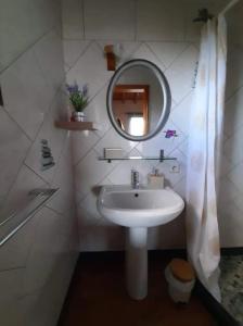ein Bad mit einem Waschbecken und einem Spiegel in der Unterkunft Ocean Melody in Canto da Areia