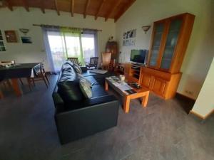 ein Wohnzimmer mit einem Sofa und einem Tisch in der Unterkunft Ocean Melody in Canto da Areia