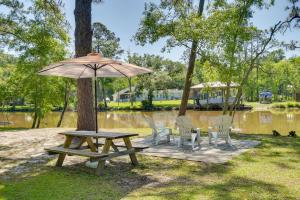 un tavolo da picnic e sedie accanto a un albero con ombrellone di Waterfront Foley Area Home - 15 Mi to Gulf! a Elberta