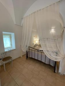 1 dormitorio con 1 cama con cortinas blancas en La Casetta di Sofia en Ceglie Messapica