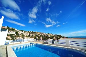a swimming pool with a hill in the background at Montemar LEK in Peñíscola