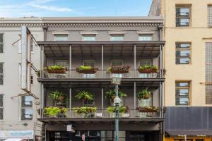 a building with potted plants on the balconies at Roami at Bourbon Place in New Orleans