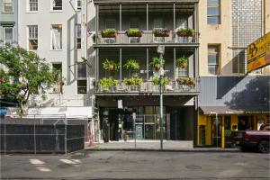 an apartment building with potted plants on the balconies at Roami at Bourbon Place in New Orleans