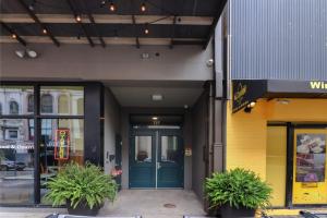 une devanture de magasin avec une porte bleue et deux plantes dans l'établissement Roami at Bourbon Place, à La Nouvelle-Orléans