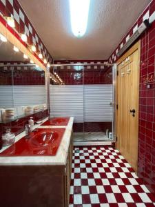 a bathroom with a red sink and a checkered floor at Sesimbra Retreat by the Sea in Sesimbra