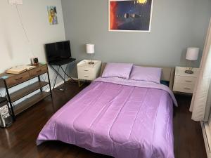 1 dormitorio con cama morada y escritorio en Shared Space with Private room in Beautiful Lakefront Apartment en Federal Way