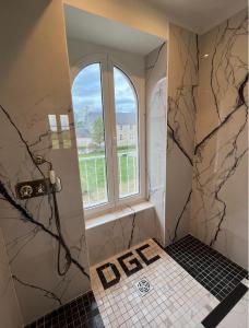 y baño con ducha y ventana. en DOMAINE DU GRAND CAUGY en Saint-Vigor-le-Grand