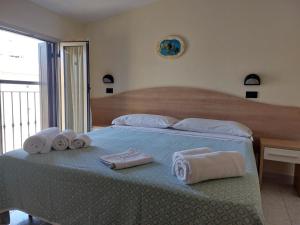 ein Schlafzimmer mit einem Bett mit Handtüchern darauf in der Unterkunft Hotel Villa Aurora in Bellaria-Igea Marina