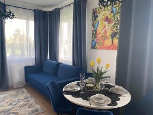 ウニエユフにあるUniLove Apartamentyのリビングルーム(青いソファ、テーブル付)