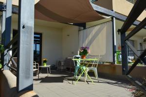 a patio with chairs and a table with flowers on it at Casa Paola in Monreale