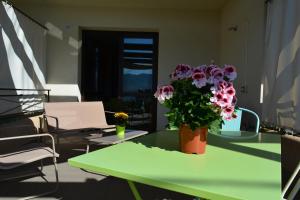 una mesa verde con un jarrón de flores. en Casa Paola, en Monreale