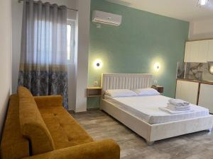 a small bedroom with a bed and a couch at Gray&Oli Studios in Vlorë