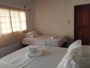 a room with two beds with towels on them at LETICIAS GUEST HOUSE in Leticia