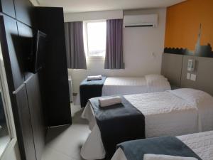 pokój hotelowy z 2 łóżkami i telewizorem w obiekcie Minuano Hotel Express próx Orla Lago Guaíba, Mercado Público, 300 m Rodoviária w mieście Porto Alegre