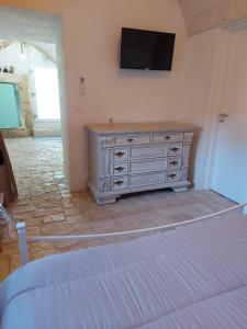 a bedroom with a dresser with a television on the wall at Le Pajare B&b in Sava