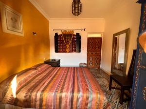 1 dormitorio con 1 cama y 1 silla en una habitación en Villa L Walida - Piscine chauffée en Esauira
