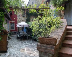 an outdoor patio with a table and an umbrella at Mulino di Castelvecchio in Borgo a Buggiano