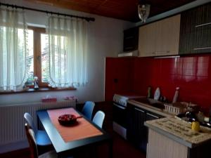 a kitchen with a small table and a kitchen with red cabinets at CASA ARTEMI in Remeţi