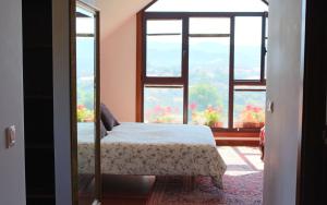 een slaapkamer met een bed en een groot raam bij Espectacular casa a dos minutos de Playa America in Nigrán