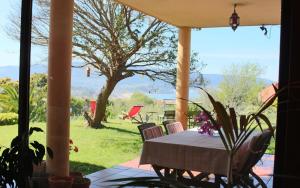 een tafel en stoelen op een veranda met uitzicht op een tuin bij Espectacular casa a dos minutos de Playa America in Nigrán