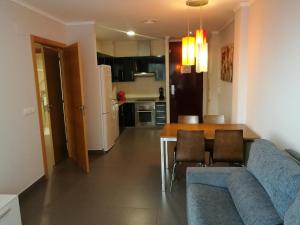 a living room with a blue couch and a table at Aparthotel El Faro in Cullera