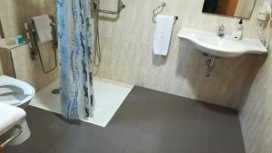 a bathroom with a sink and a toilet at Aparthotel El Faro in Cullera