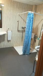 a bathroom with a blue shower curtain on the floor at Aparthotel El Faro in Cullera