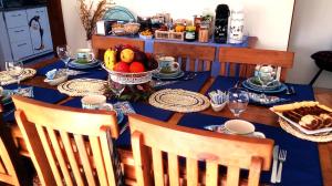 a table with a blue table cloth and fruit on it at Pousada da Gigoia - Barra da Tijuca in Rio de Janeiro