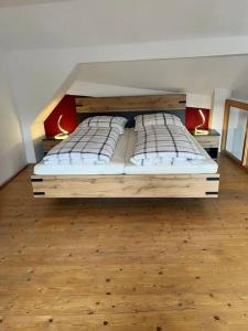 two beds in a room with a wooden floor at Wanderurlaub mit und ohne Hund! in Harra