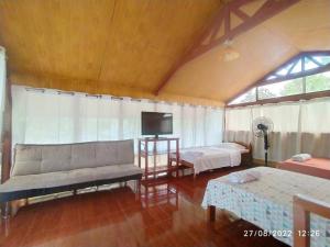 een woonkamer met een bank en een tv bij Casita Grau 2! Naturaleza y confort con Agua caliente,cocina y frigobar in Tarapoto