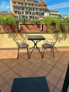 2 Stühle und ein Tisch auf der Terrasse in der Unterkunft Hotel Principe Di Piemonte in Rom