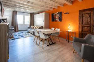 a dining room with orange walls and a table and chairs at FITZ ROY Annecy Rent Lodge in Annecy