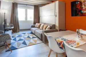 ein Wohnzimmer mit einem Sofa und einem Tisch in der Unterkunft FITZ ROY Annecy Rent Lodge in Annecy