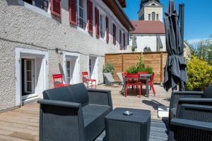 a patio with chairs and an umbrella and a table at HIMALAYA Annecy Rent Lodge in Annecy
