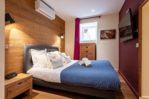 ein Schlafzimmer mit einem Bett mit einem blauen Ottomanen in der Unterkunft APPENNINS Annecy Rent Lodge in Annecy