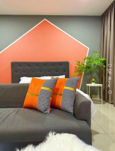 un cuscino arancione e nero su un letto in una stanza di 4 pax cozy homestay Trefoil Setia City Mall SCCC 12-16 a Shah Alam